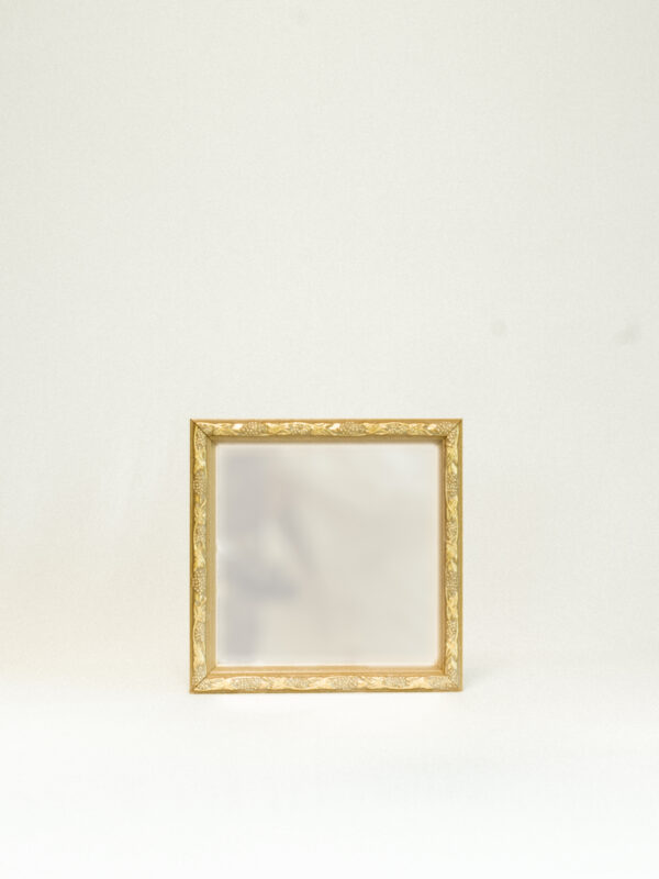 brass mirror against white backgound