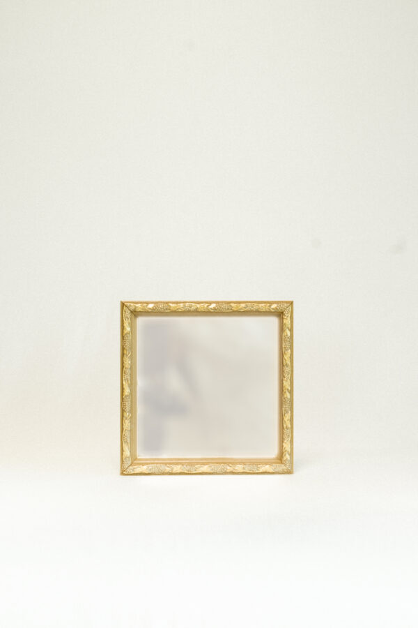 brass mirror against white backgound