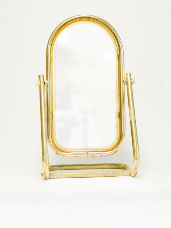 antique brass mirror against white background